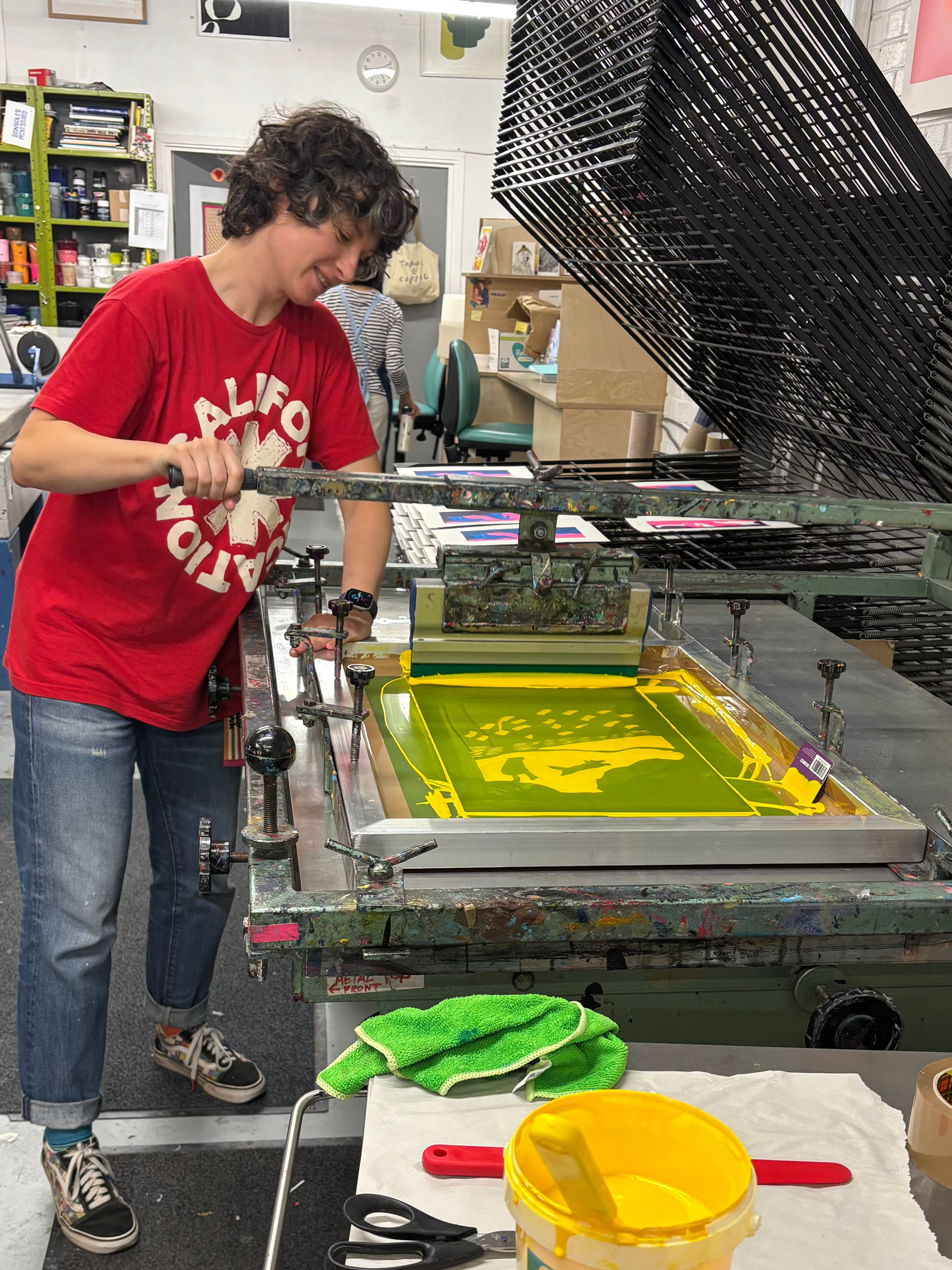 Person working with yellow ink in a printmaking studio